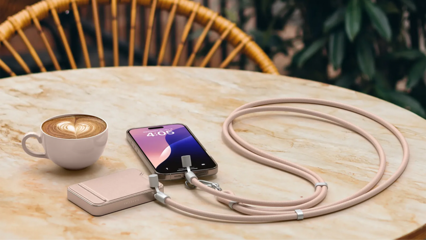 Естетика мобільного офісу: ремінець-кабель Satechi On-the-Go кольору Desert Rose заряджає iPhone від магнітного павербанка Satechi на столику в кав'ярні.